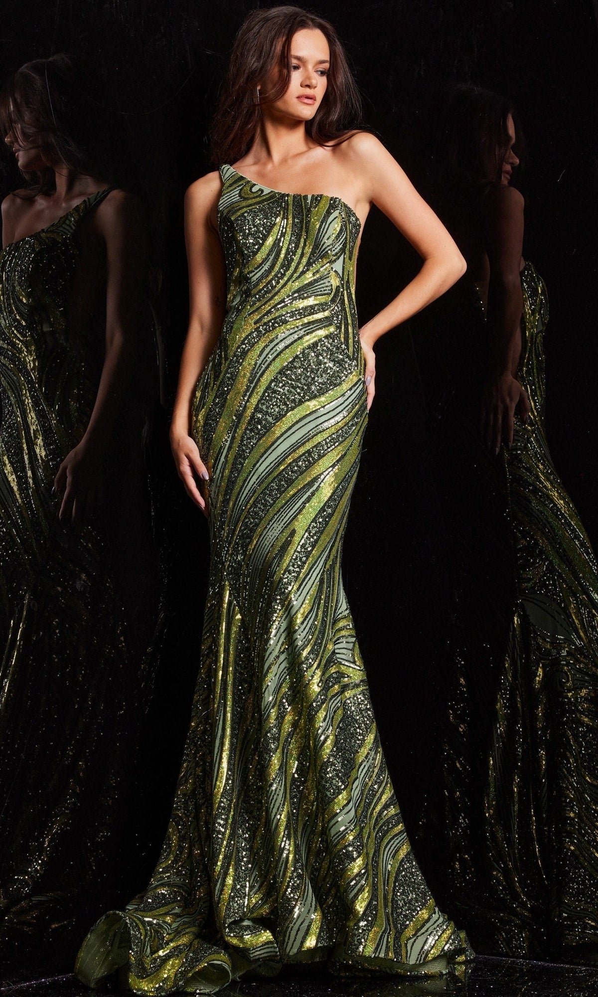 A woman poses against a dark reflective background in the Jovani One-Shoulder Long Sequin Prom Dress 24031, featuring fitted styling and swirling green and black patterns.